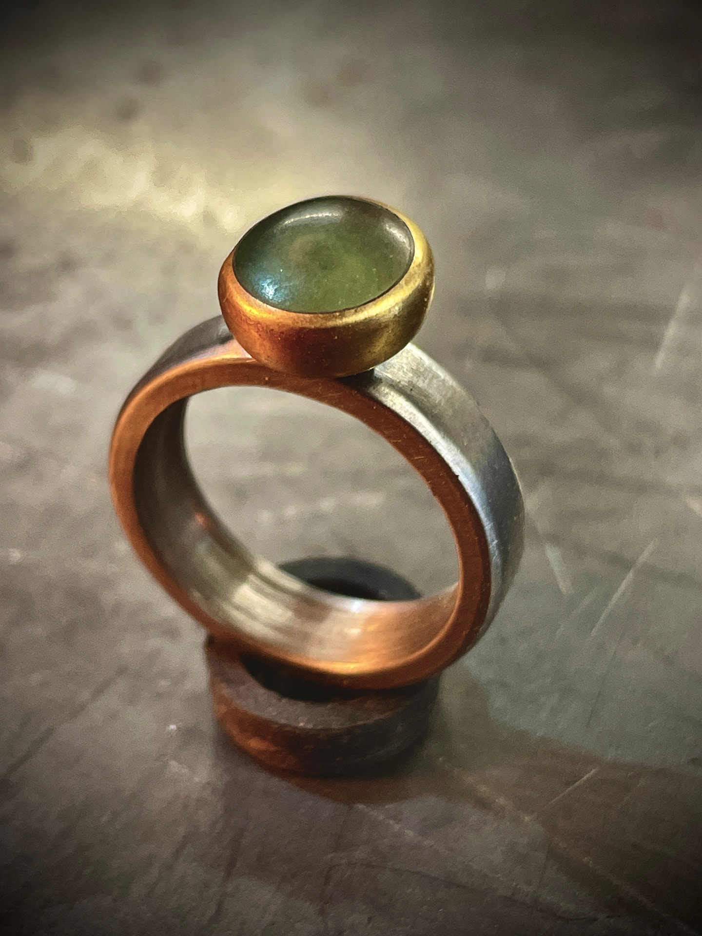 Mixed-metal ring with a green stone setting