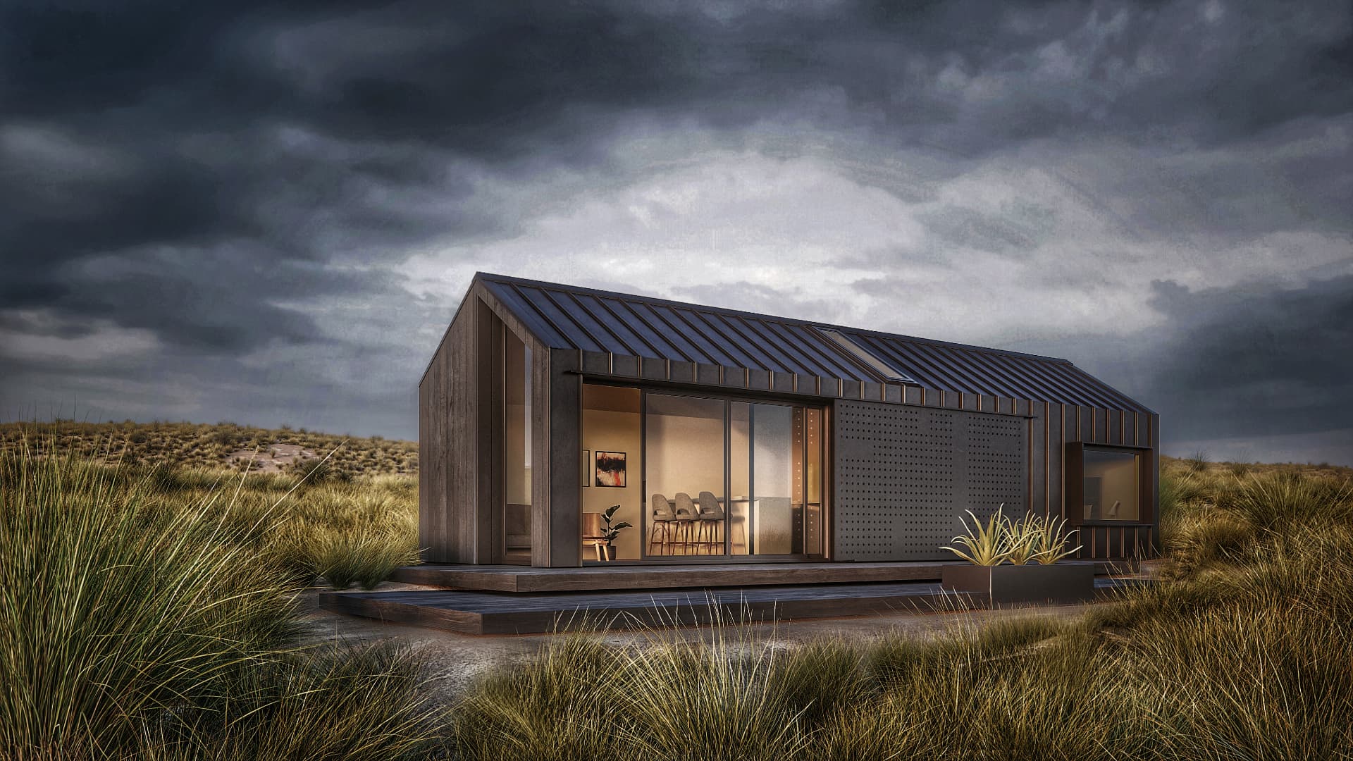 Timber-clad gabled modular dwelling with a perforated sliding screen in a tussock landscape