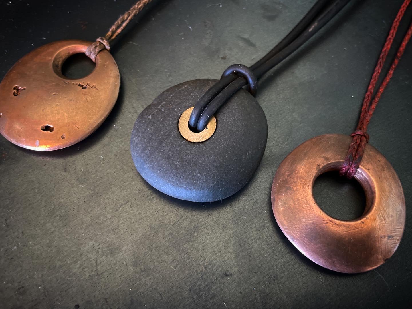 Copper, stone and brass pendants on dark cords