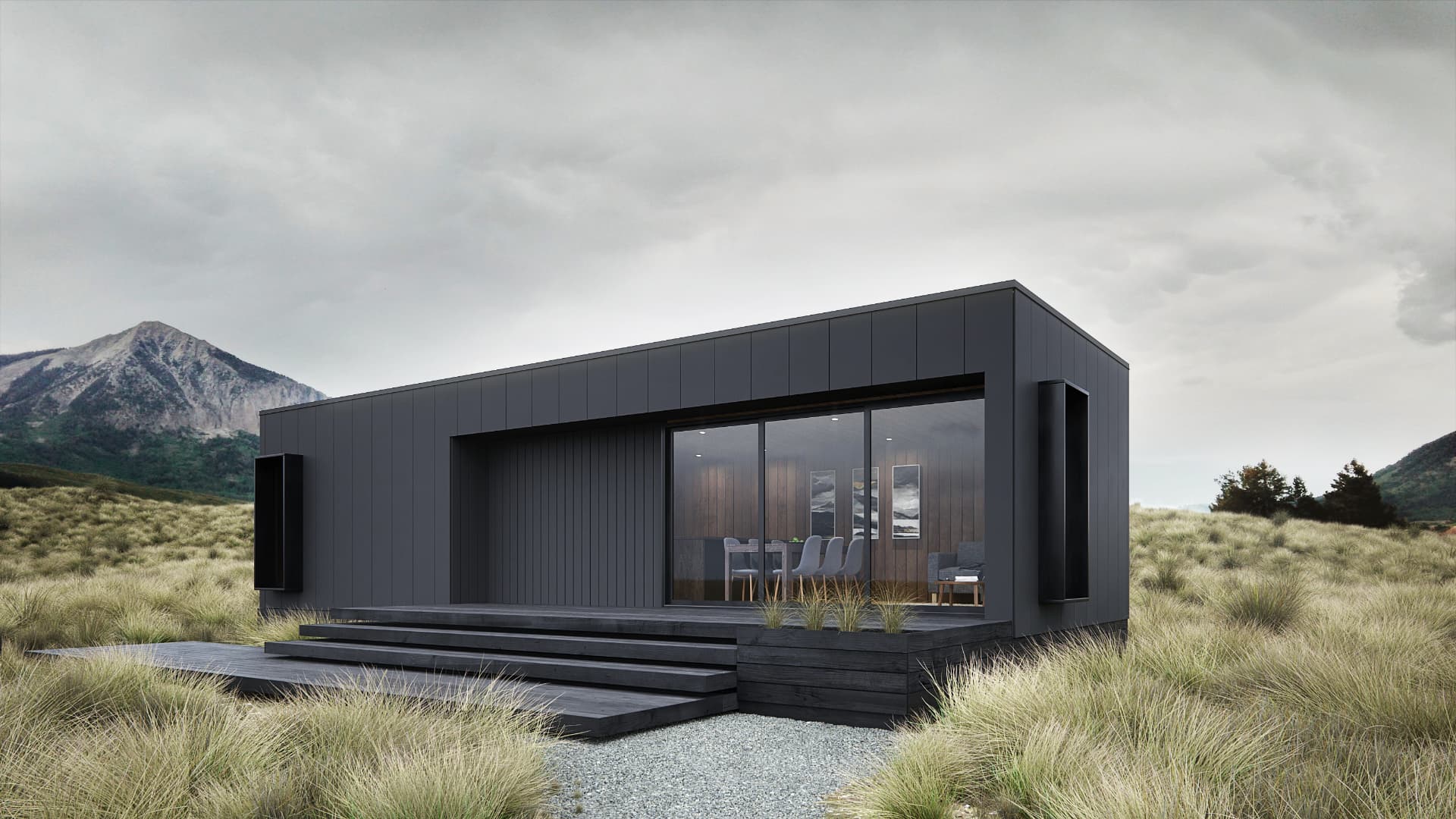 Dark-clad modular dwelling with a broad glazed frontage and stepped deck in an alpine landscape